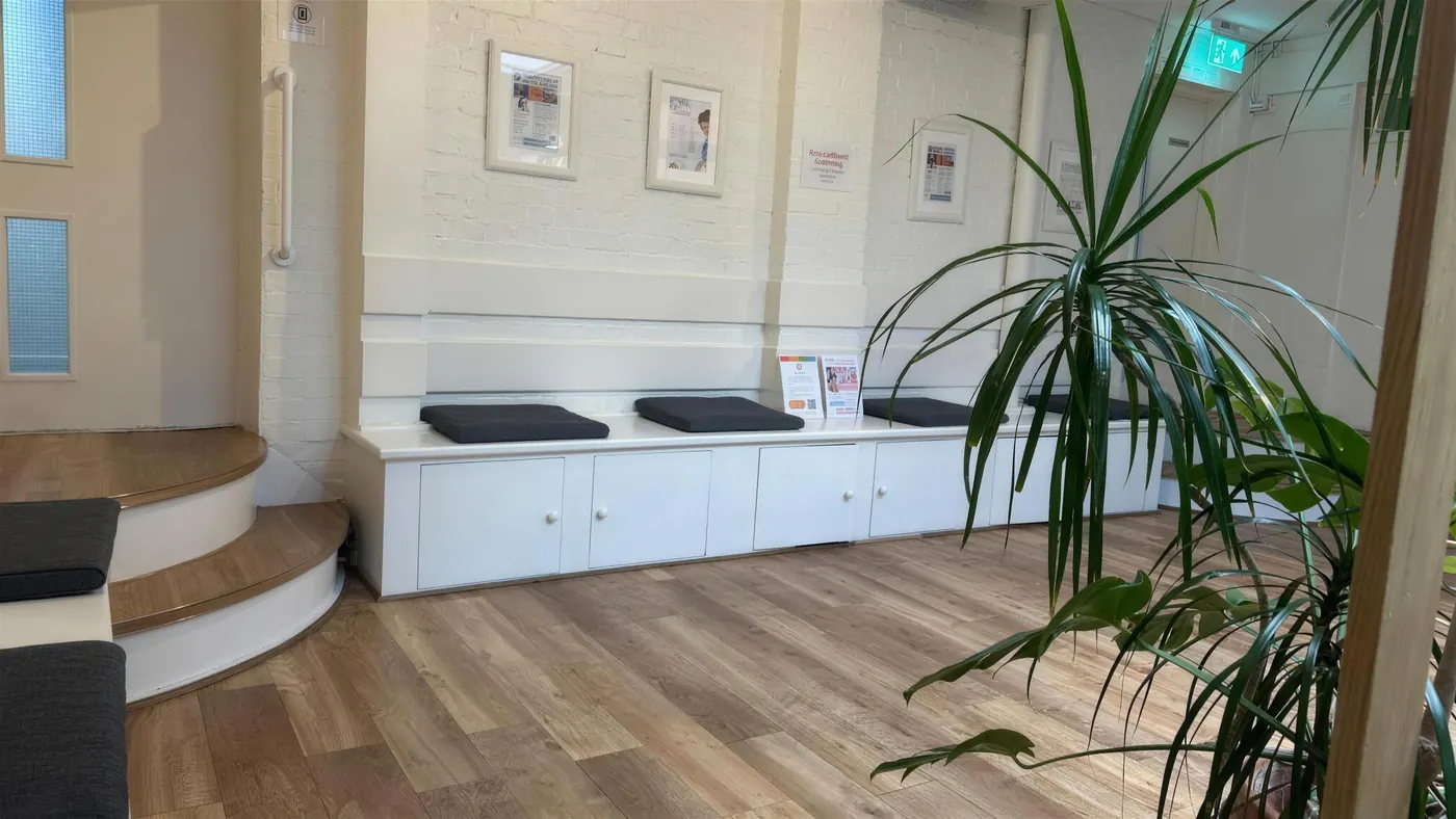 Waiting area with cushioned benches along a white wall